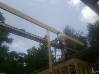 Carpenter setting a ridge beam over a new addition frame — Ice Dam Removal by Roofing Brothers in Powderly
