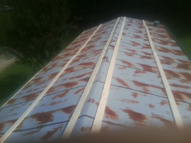 Rusted metal roof panels with new wood purlins before replacement — Storm Damage Roof Repair in Powderly by Roofing Brothers